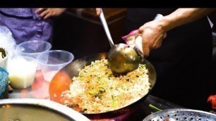 'Chinese Street Food -Fried rice noodles with eggs at night market, fired  dish   and spicy fish'